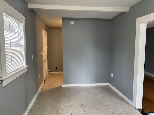 tiled empty room with a textured ceiling