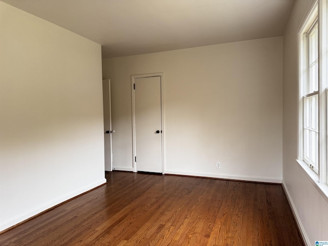 unfurnished room with dark hardwood / wood-style flooring and a wealth of natural light