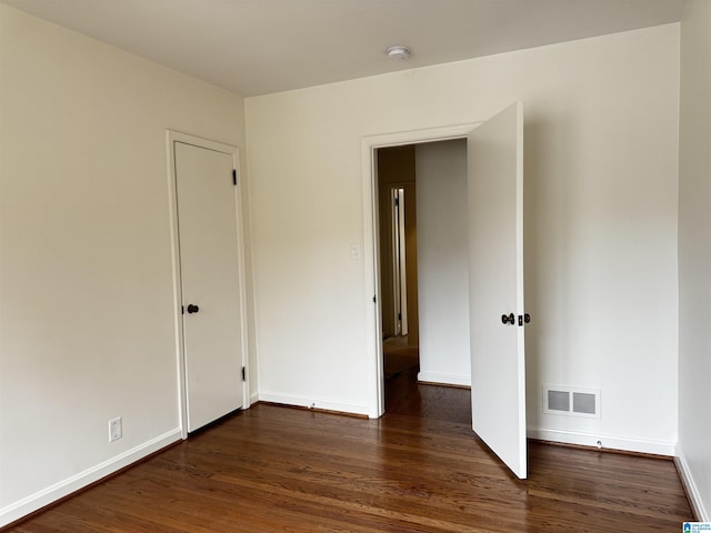 unfurnished bedroom with dark hardwood / wood-style floors