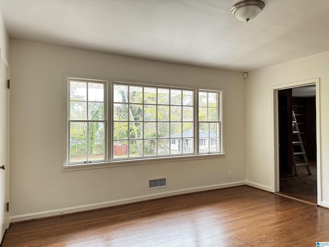 unfurnished bedroom with a closet, dark hardwood / wood-style flooring, and a spacious closet