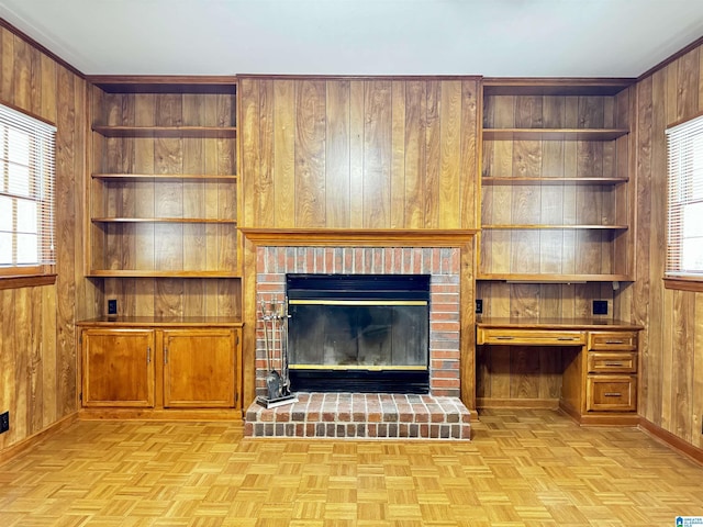 unfurnished living room featuring light parquet floors, plenty of natural light, and wood walls