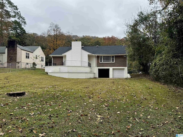 rear view of property featuring a yard and a garage