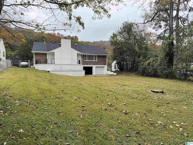 rear view of house with a yard and a garage