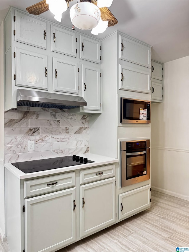 kitchen with backsplash, light hardwood / wood-style flooring, and stainless steel appliances