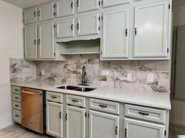 kitchen featuring dishwasher, backsplash, light hardwood / wood-style floors, and sink