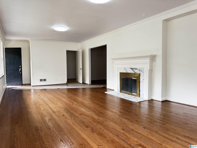 unfurnished living room featuring a fireplace, wood-type flooring, and crown molding