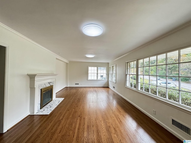 unfurnished living room featuring dark hardwood / wood-style flooring, a premium fireplace, and ornamental molding