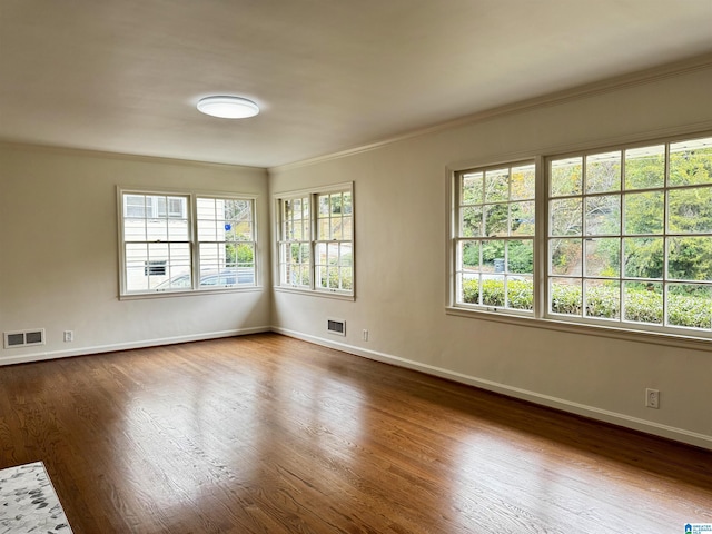 unfurnished room featuring wood-type flooring and ornamental molding