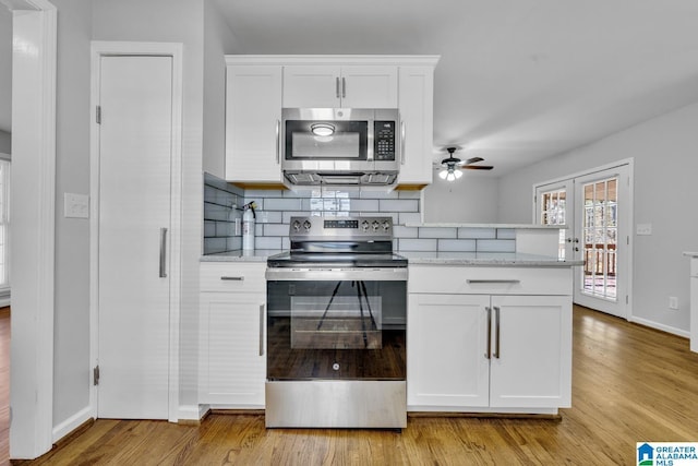 kitchen featuring light stone countertops, light wood-type flooring, white cabinetry, and appliances with stainless steel finishes