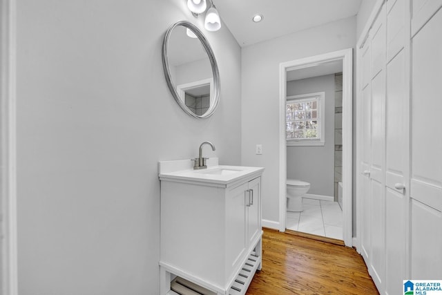 bathroom featuring hardwood / wood-style floors, vanity, and toilet