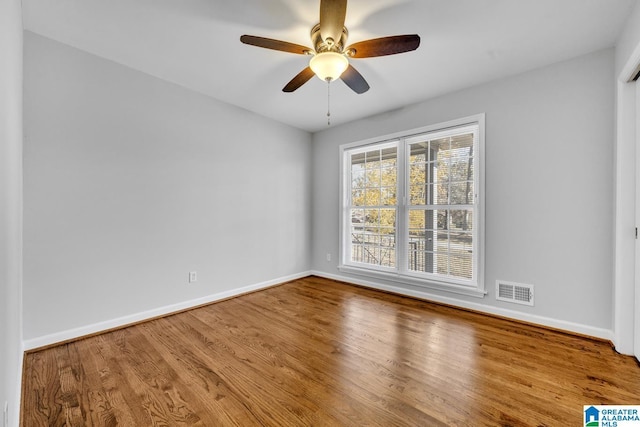 spare room with hardwood / wood-style floors and ceiling fan