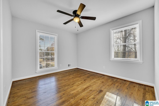 empty room with hardwood / wood-style floors and ceiling fan