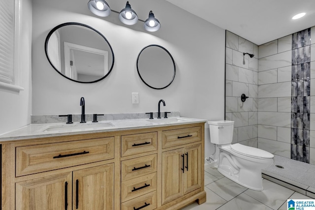 bathroom featuring tile patterned floors, vanity, toilet, and tiled shower