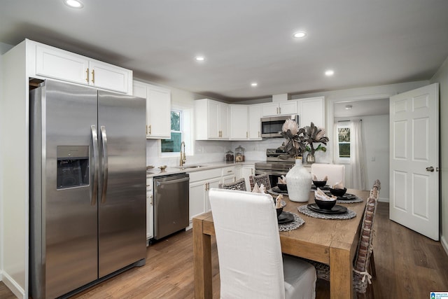 kitchen featuring stainless steel appliances, a healthy amount of sunlight, and light hardwood / wood-style floors