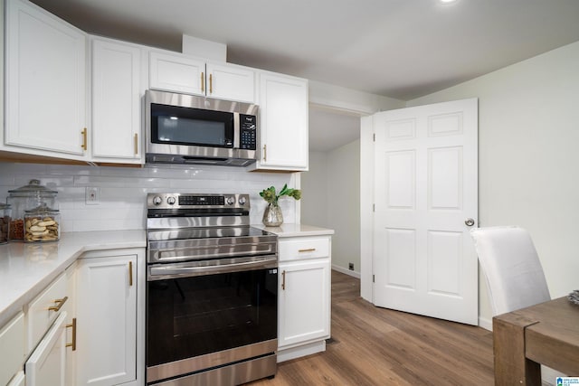 kitchen featuring backsplash, white cabinetry, hardwood / wood-style floors, and appliances with stainless steel finishes