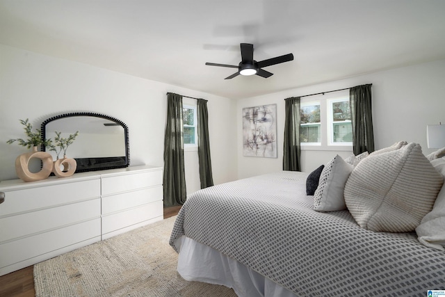 bedroom with hardwood / wood-style flooring, multiple windows, and ceiling fan