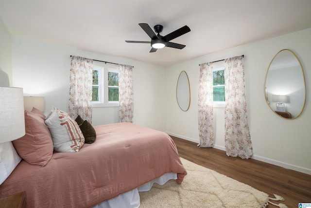 bedroom featuring multiple windows, ceiling fan, and dark hardwood / wood-style floors