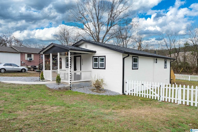 single story home with covered porch and a front yard