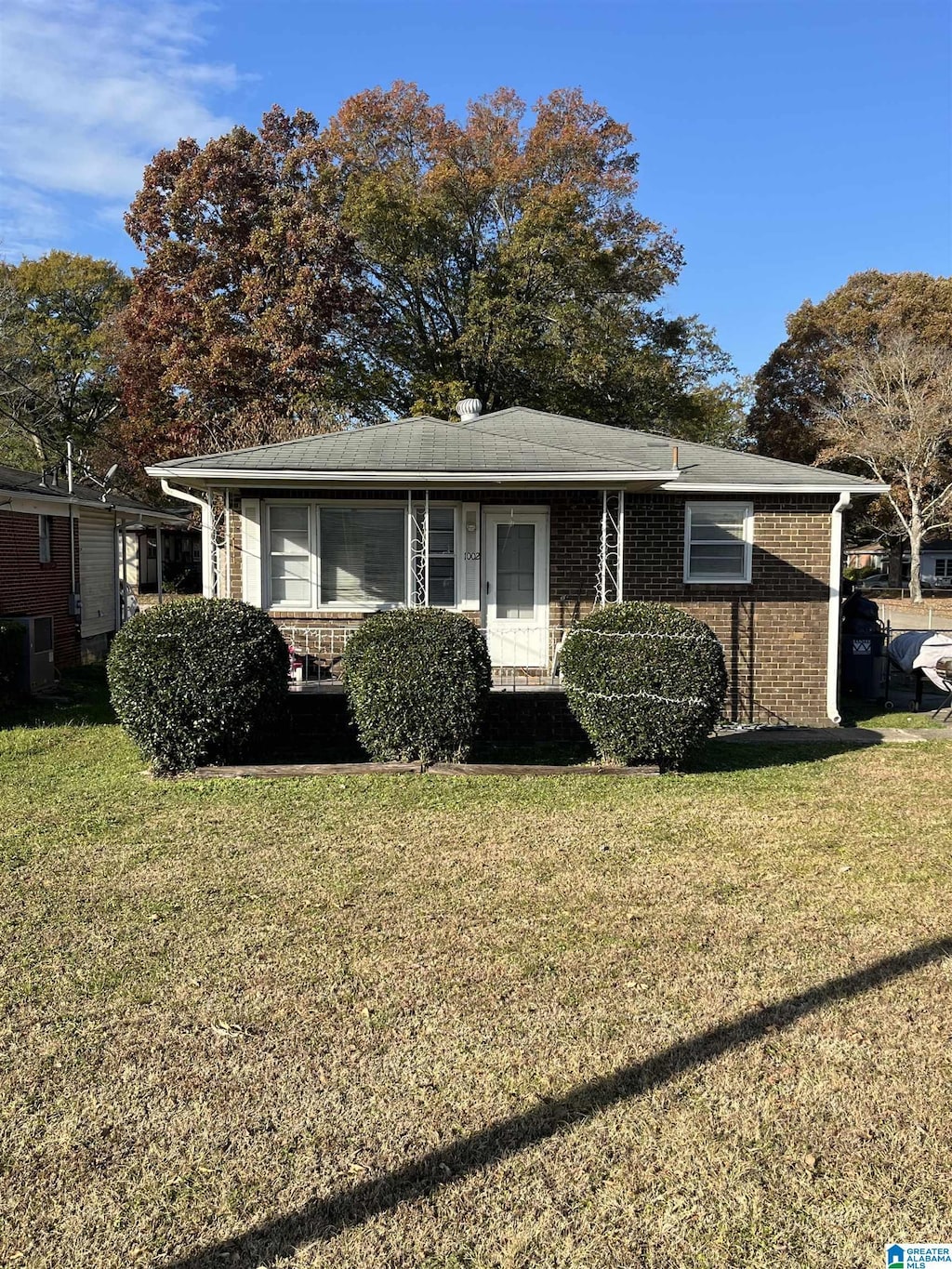 view of front facade featuring a front yard and central AC unit