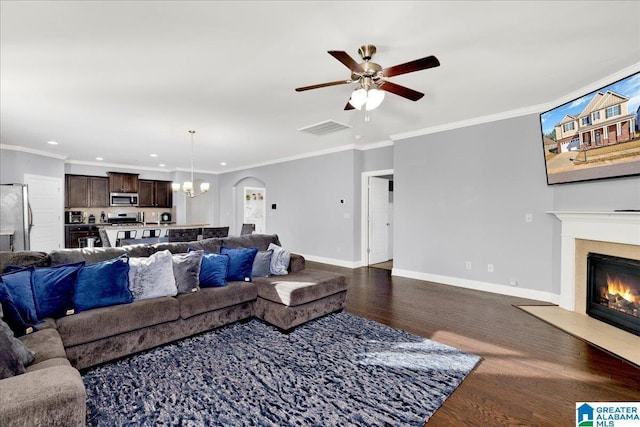 living room with ceiling fan with notable chandelier, crown molding, and dark wood-type flooring