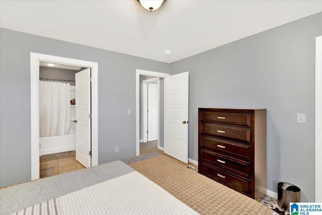 bedroom featuring connected bathroom and light tile patterned flooring