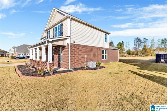 view of home's exterior featuring a lawn and central AC