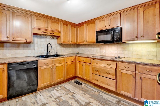 kitchen featuring light stone countertops, sink, tasteful backsplash, and black appliances