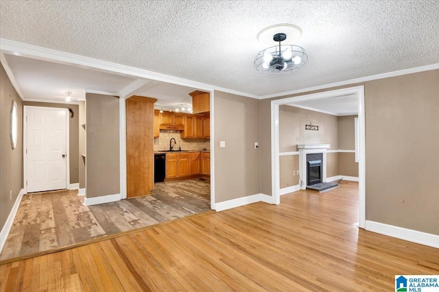 interior space featuring sink, crown molding, a textured ceiling, and light hardwood / wood-style flooring