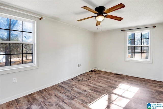 unfurnished room featuring ceiling fan, wood-type flooring, a textured ceiling, and ornamental molding