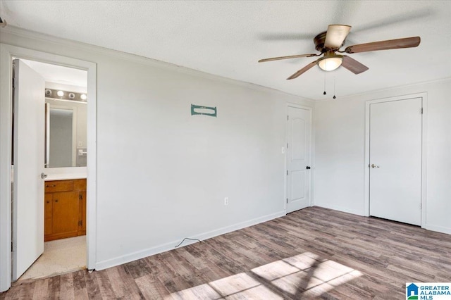 unfurnished bedroom featuring connected bathroom, ceiling fan, and light wood-type flooring