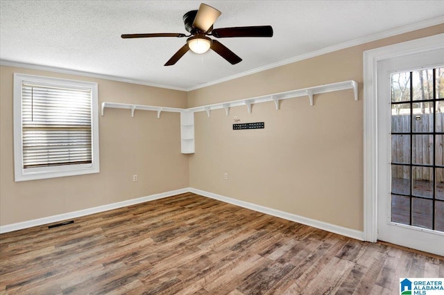 empty room featuring ceiling fan, ornamental molding, a textured ceiling, and hardwood / wood-style flooring