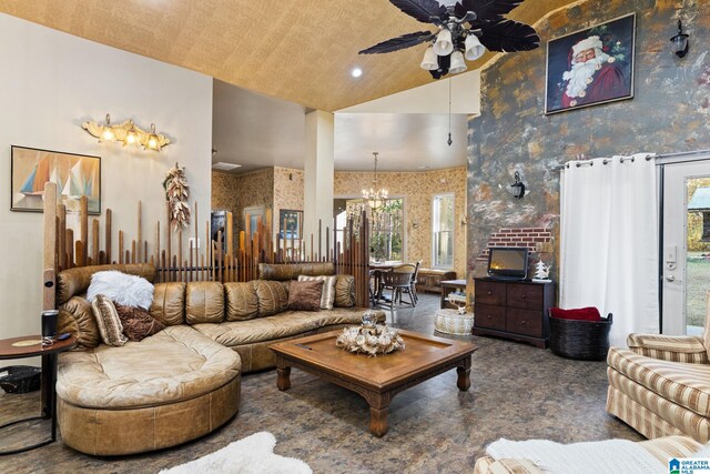 carpeted living room with plenty of natural light, high vaulted ceiling, and ceiling fan with notable chandelier