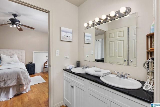 bathroom with hardwood / wood-style floors, vanity, and ceiling fan