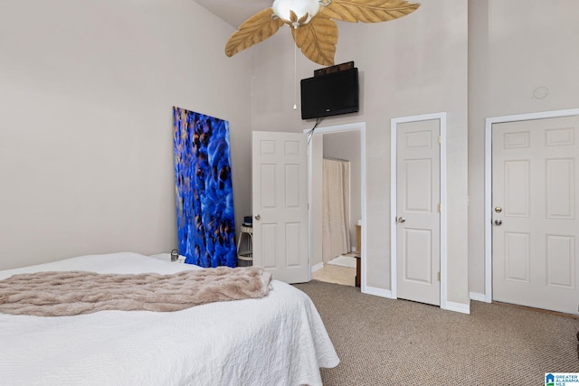 bedroom with carpet flooring, a high ceiling, and ceiling fan