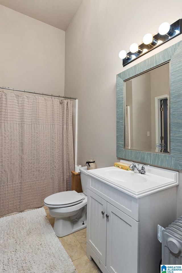 bathroom featuring tile patterned flooring, vanity, and toilet