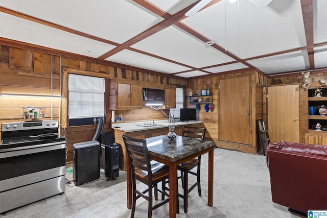 dining room with beam ceiling, sink, coffered ceiling, light colored carpet, and wooden walls