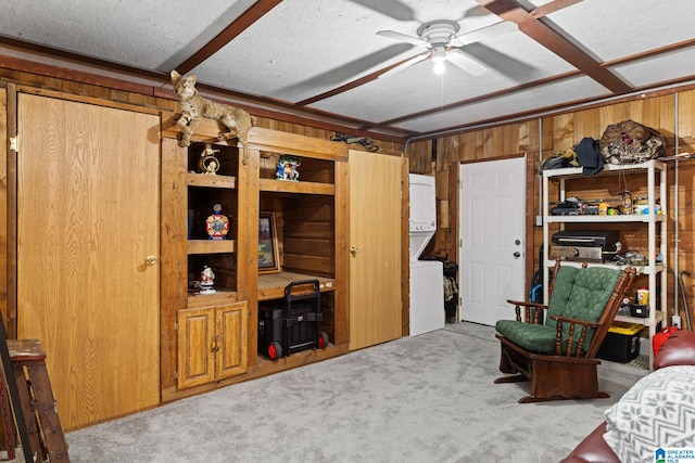 carpeted bedroom with a textured ceiling, ceiling fan, and wooden walls