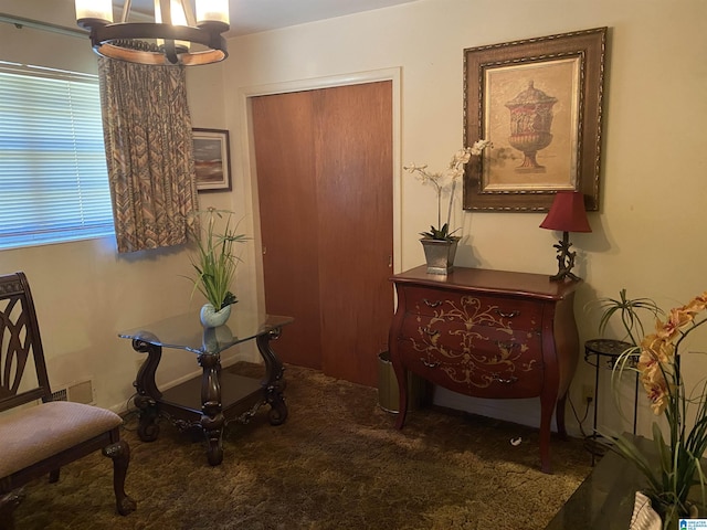 sitting room featuring carpet and a chandelier