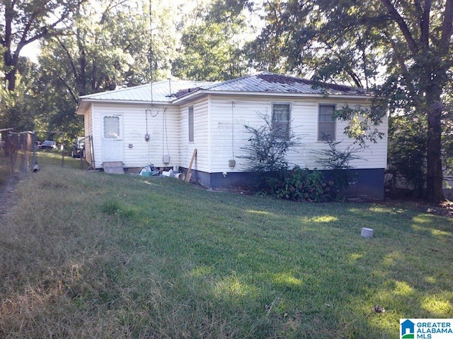 view of side of home with a yard