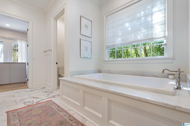 bathroom featuring a bath, toilet, and ornamental molding