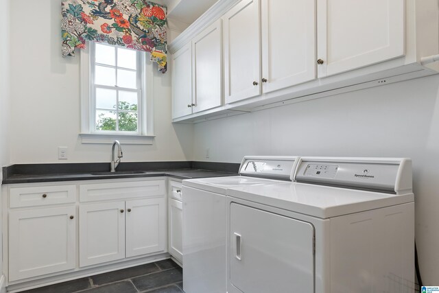 laundry area featuring cabinets, separate washer and dryer, and sink