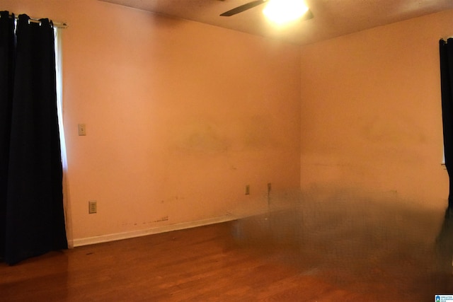 empty room with baseboards, wood finished floors, and ceiling fan