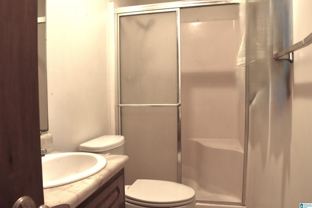 full bath featuring a stall shower, toilet, and vanity