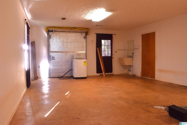 interior space featuring concrete floors, a sink, and washer / clothes dryer