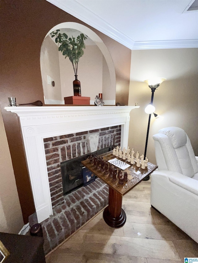 sitting room featuring a fireplace, light hardwood / wood-style flooring, and ornamental molding