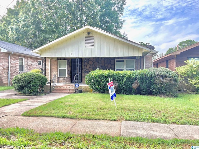 bungalow-style home with a front lawn and a porch