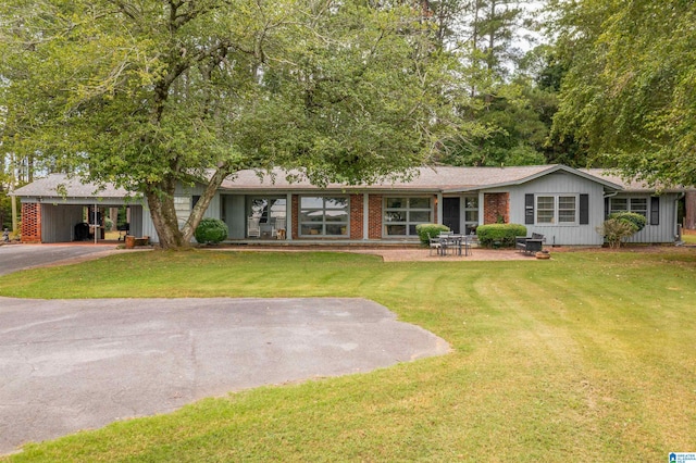 ranch-style house with a carport and a front lawn