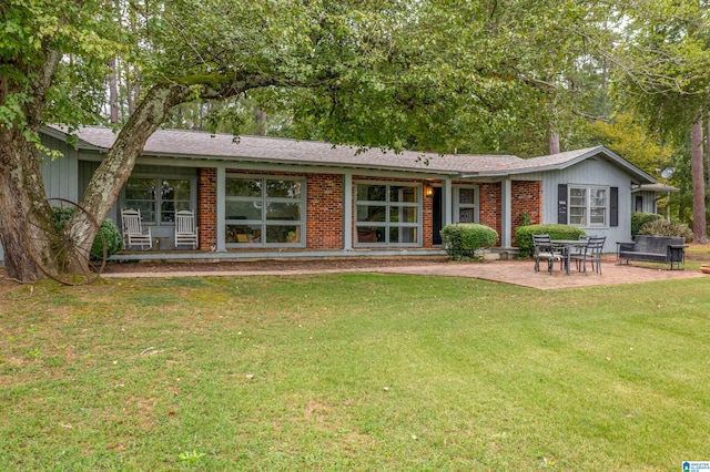 back of house with a yard and a patio