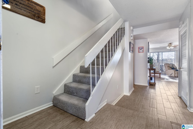 stairway featuring hardwood / wood-style flooring and ceiling fan