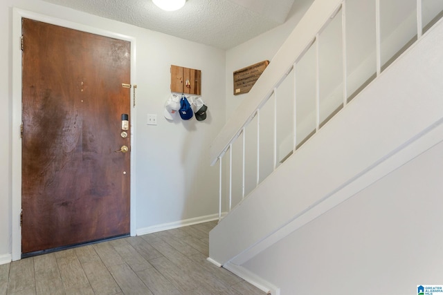 entrance foyer featuring light wood-type flooring and a textured ceiling